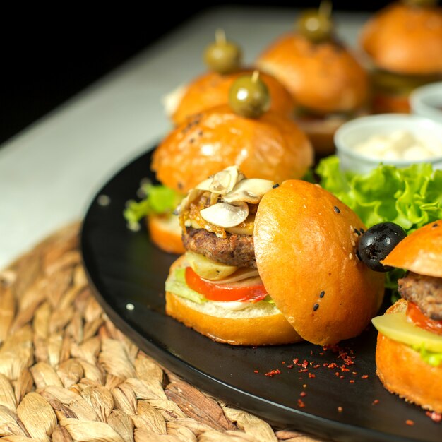 Mini hamburger di carne vista laterale con olive