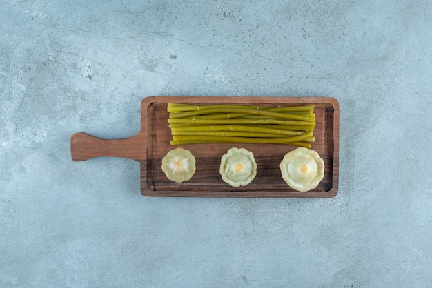 Mini zucca marinata deliziosa e bastoncini su una tavola, sul tavolo di marmo.