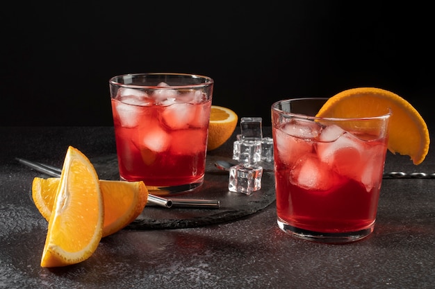Miscela di cocktail rinfrescanti con frutta d'arancia e cubetti di ghiaccio