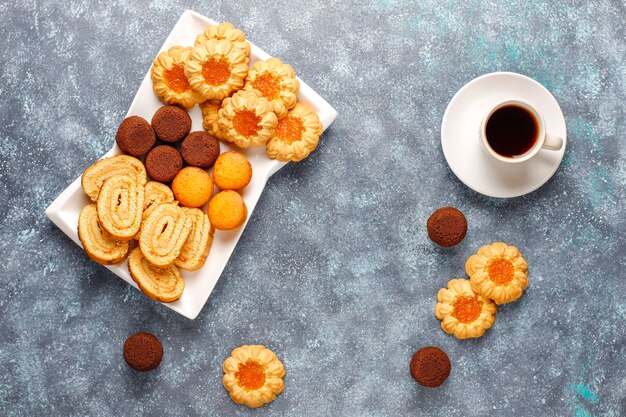 Mix di biscotti dolci, rotolo di torta, mini cupcakes.