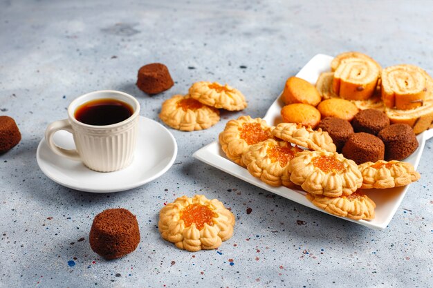 Mix di biscotti dolci, rotolo di torta, mini cupcakes.