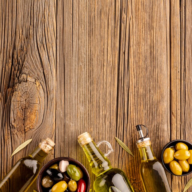 Mix di olive in ciotole e bottiglie di olio d'oliva con spazio di copia