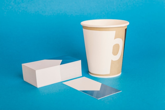 Mockup di cancelleria con biglietti da visita caffè per andare la tazza