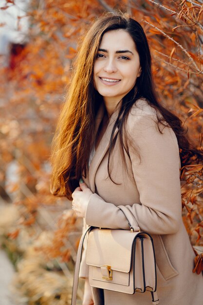 Moda ragazza che cammina in un parco di primavera