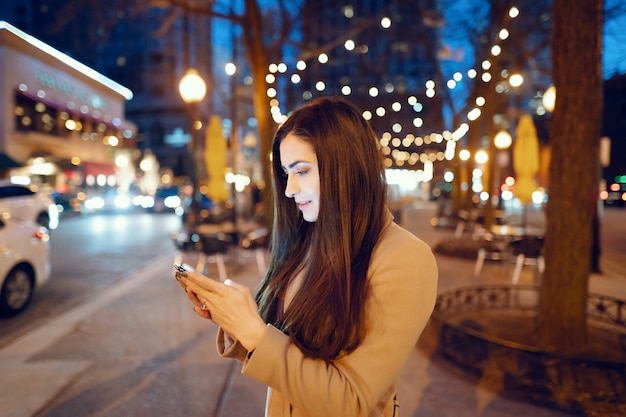 Moda ragazza che cammina in una città di sera