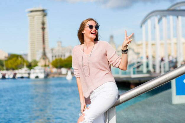 Moda ritratto di sensuale sorprendente l hipster donna in abito casual pastello di primavera, gioielli alla moda, labbra rosse che godono le vacanze a Barcellona.