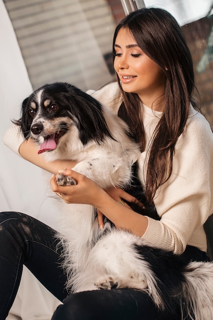 Modella in camicia bianca con cane bianco nero