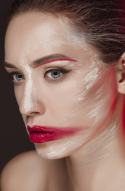 Modella ragazza con la faccia colorata dipinta.