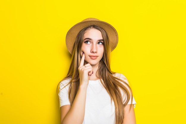 Modello carino in maglietta bianca e cappello tra sfondo arancione con faccia buffa