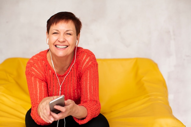 Modello d'ascolto di musica della donna senior dell'angolo alto