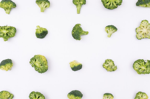 Modello dei broccoli sistemato fila per fila su superficie bianca