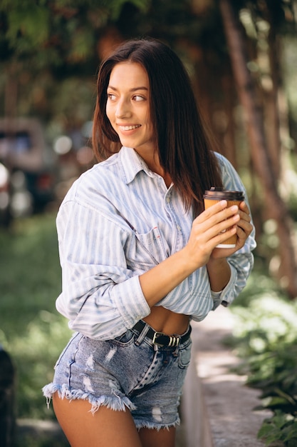 Modello della donna in camicia da uomo bere caffè