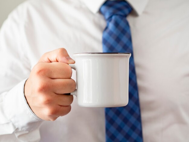 Modello della tazza da caffè della tenuta della mano del primo piano