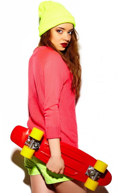 Modello di alta moda look.glamor elegante sexy bella giovane donna bruna in panno luminoso hipster estate in berretto giallo con skateboard