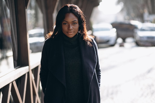 Modello di donna afro-americana in cappotto in strada