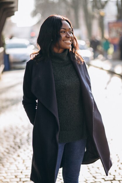 Modello di donna afro-americana in cappotto in strada