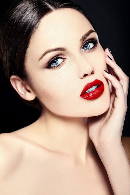 Modello di giovane donna caucasica con trucco luminoso, pelle pulita perfetta e labbra rosse colorate