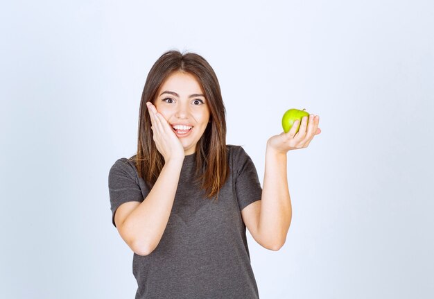modello di giovane donna che tiene una mela verde.