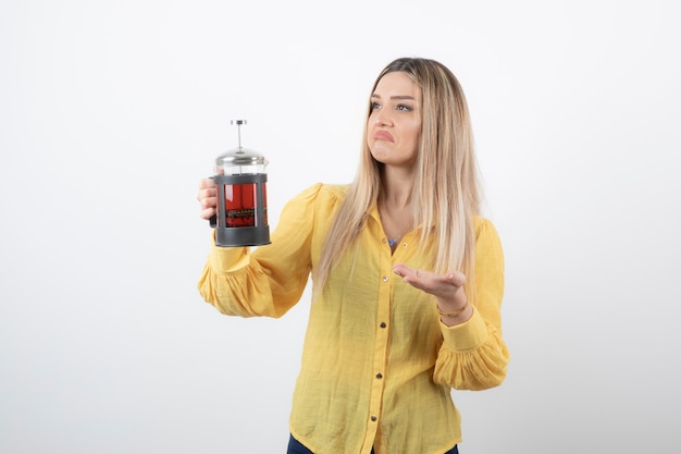 modello di giovane donna graziosa che tiene una teiera.