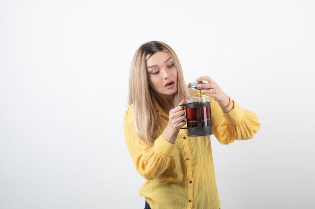 modello di giovane donna graziosa che tiene una teiera.