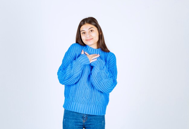 modello di giovane ragazza in maglione blu in piedi e in posa.