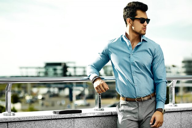 modello di giovane uomo d'affari bello uomo in panno casual in occhiali da sole in strada