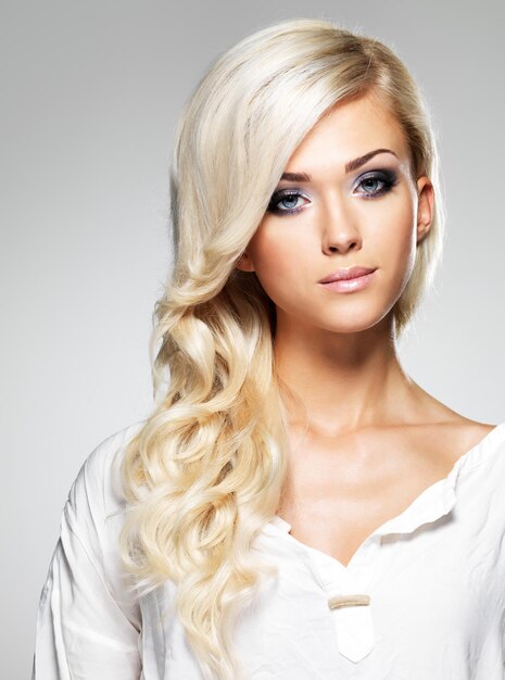 Modello di moda con lunghi capelli bianchi e trucco luminoso. Ritratto di donna glamour