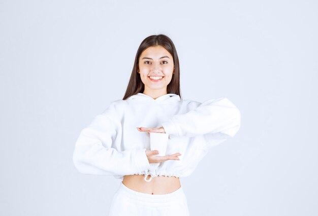 modello di ragazza carina che tiene un bicchiere di plastica.