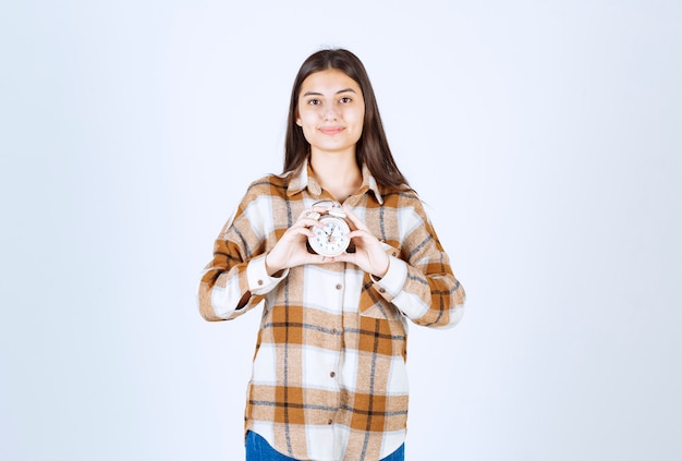 modello di ragazza piuttosto giovane che tiene una sveglia.