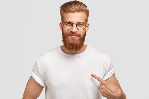 Modello di uomo attraente con barba e pettinatura alla moda, vestito con una maglietta bianca