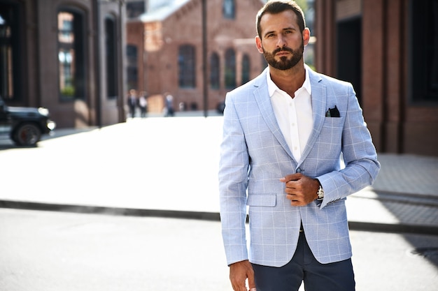 modello di uomo d'affari moda bello vestito in elegante abito blu in posa sulla strada