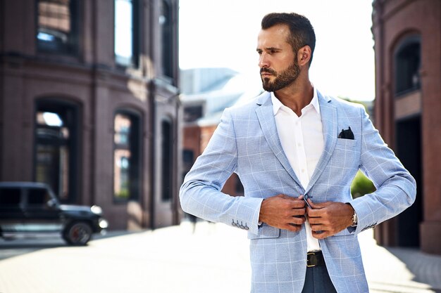 modello di uomo d'affari moda bello vestito in elegante abito blu in posa sulla strada