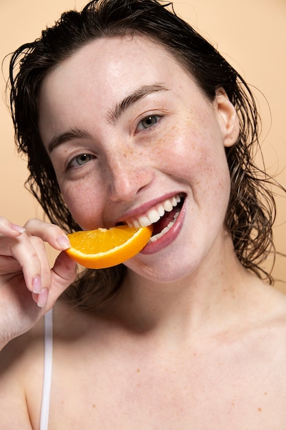 Modello di vista frontale che mangia arancia