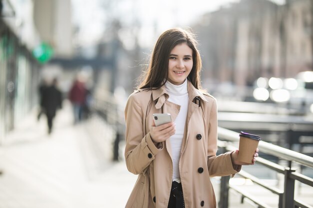 Modello femminile adorabile che beve caffè dentro il grande centro commerciale