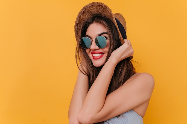 Modello femminile bianco sbalorditivo con rossetto rosso che tocca i suoi capelli e distoglie lo sguardo