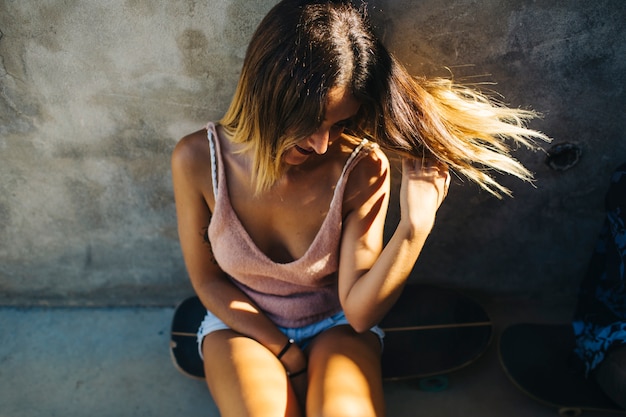 Modello femminile in posa con lo skateboard