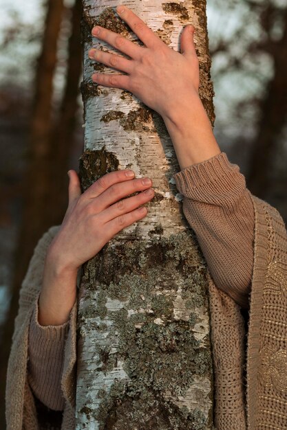 Modello maschio che abbraccia un albero