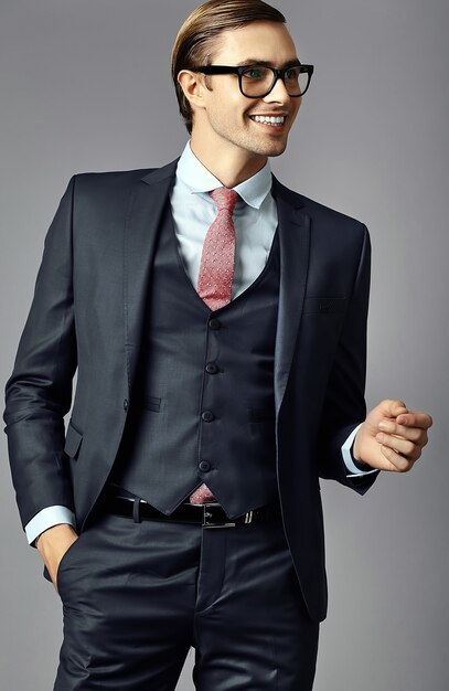 Modello maschio dell'uomo d'affari bello elegante sorridente dei giovani in vestito e vetri alla moda