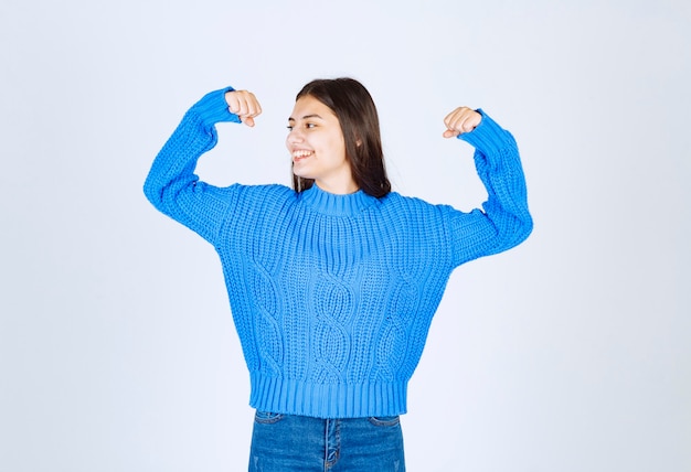 modello positivo della ragazza che indica al suo bicipite.