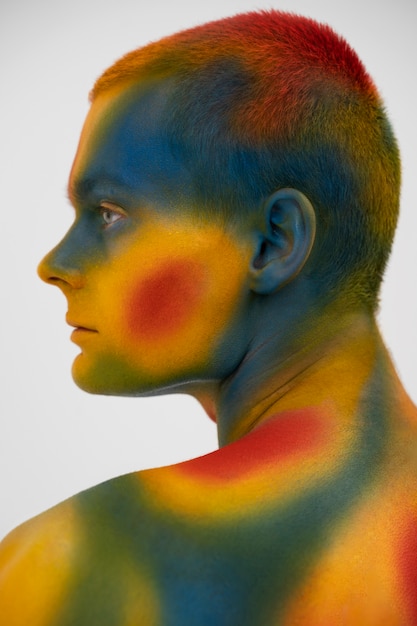 Modello uomo in posa con body painting colorato