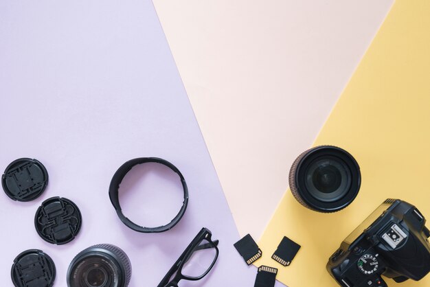 Moderna fotocamera dslr con accessori per fotocamere e spettacolo su sfondo colorato