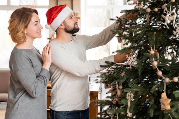 Moglie e marito decorano l'albero