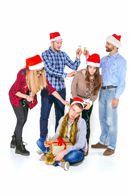 Molte giovani donne e uomini che bevono alla festa di Natale su sfondo bianco studio