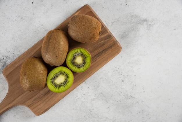 Molti dei deliziosi kiwi su tavola di legno.