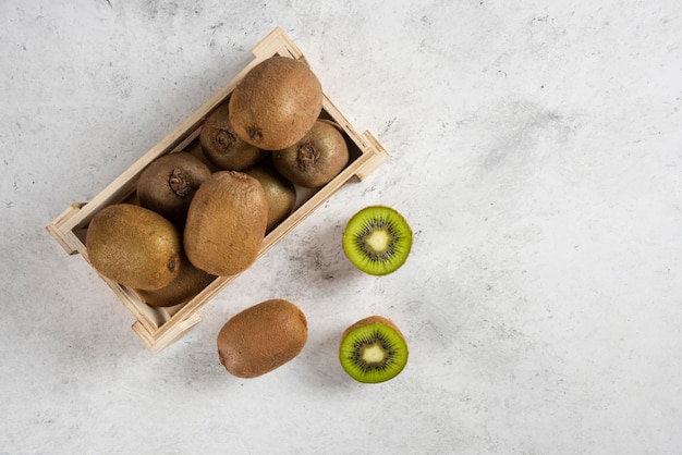 Molti dei kiwi freschi sul cestino di legno.