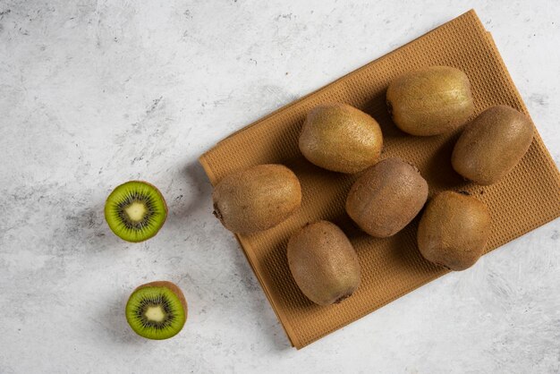 Molti dei kiwi freschi sulla tovaglia marrone.