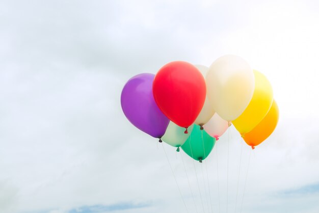 Molti palloncini colorati sul cielo blu, concetto di amore in estate e valentina, luna di miele di nozze. Immagini di stile d&#39;effetto vintage.