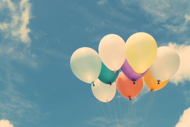 Molti palloncini colorati sul cielo blu, concetto di amore in estate e valentina, luna di miele di nozze. Immagini di stile d&#39;effetto vintage.