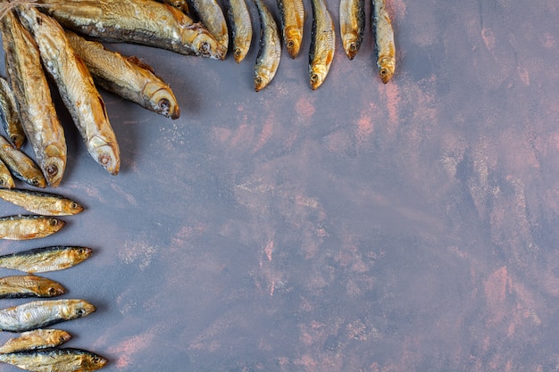 Molto pesce salato essiccato sulla superficie del marmo