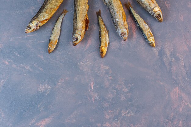 Molto pesce salato essiccato sulla superficie del marmo